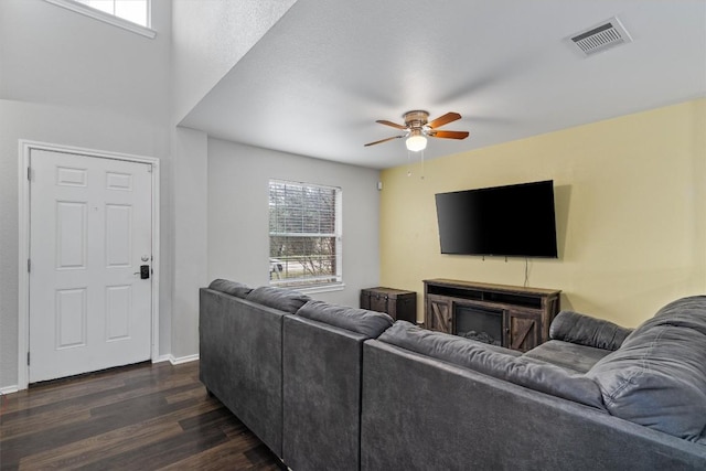 living room with dark wood-type flooring and ceiling fan