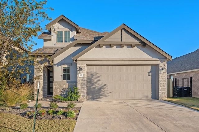 craftsman-style home with a standing seam roof, fence, an attached garage, stucco siding, and concrete driveway