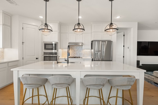 117 Dycus Bnd, Liberty Hill, TX 78642 - kitchen featuring stainless steel appliances, under cabinet range hood, backsplash, white cabinetry, and recessed lighting