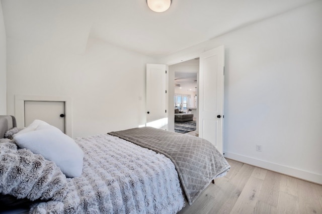 bedroom featuring baseboards and light wood finished floors