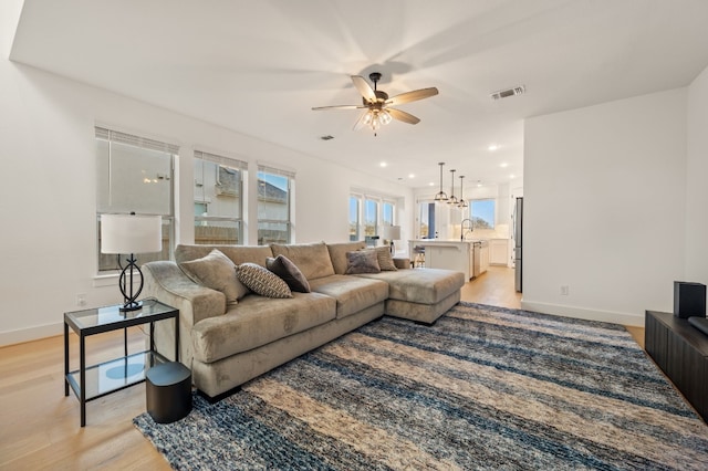 living room with light wood-style flooring, recessed lighting, baseboards, ceiling fan, and visible vents