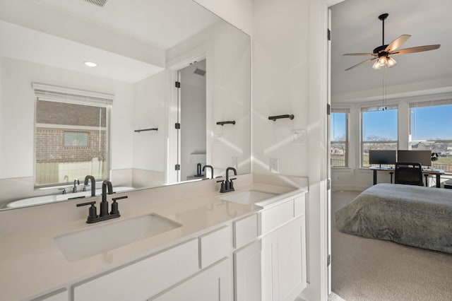 full bath featuring double vanity, a ceiling fan, and a sink