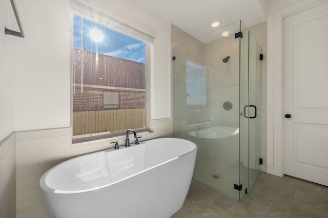 bathroom with a shower stall and a freestanding tub