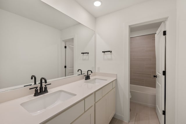 full bath featuring double vanity, tile patterned flooring, and a sink