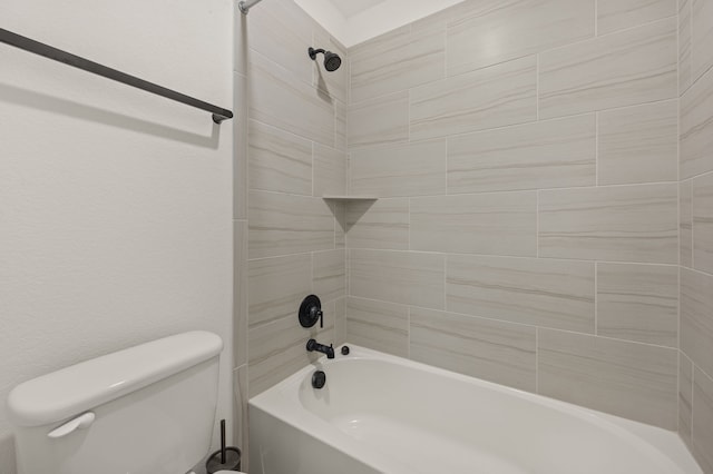 bathroom featuring toilet and tiled shower / bath