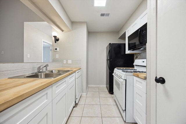 kitchen with light tile patterned floors, wooden counters, white appliances, white cabinets, and sink