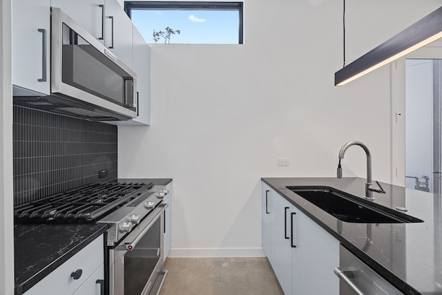 kitchen with sink, white cabinetry, backsplash, and appliances with stainless steel finishes