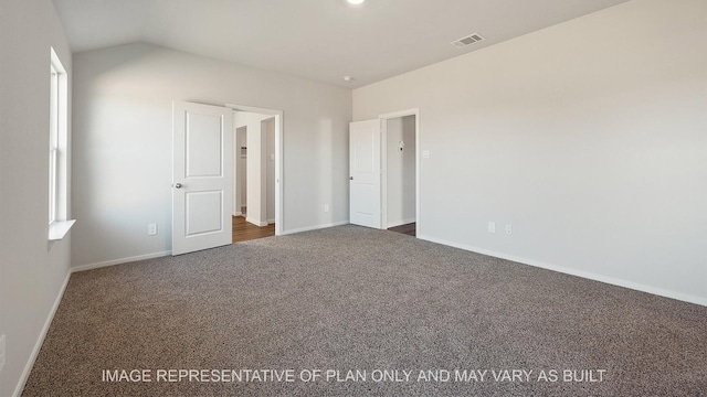 unfurnished bedroom with vaulted ceiling and dark colored carpet