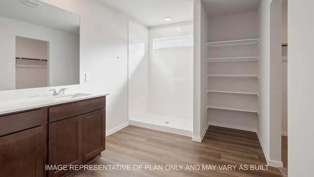 bathroom featuring a shower, hardwood / wood-style flooring, and vanity