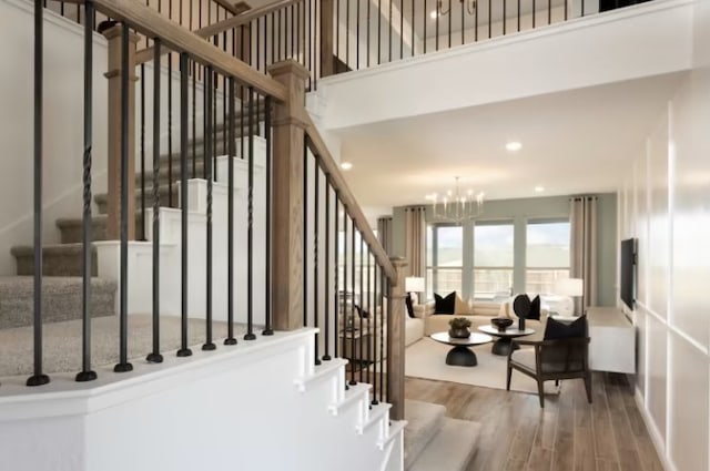 stairs featuring an inviting chandelier and hardwood / wood-style flooring