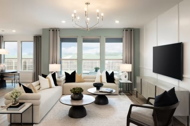 living room featuring a wealth of natural light, a chandelier, and light hardwood / wood-style floors