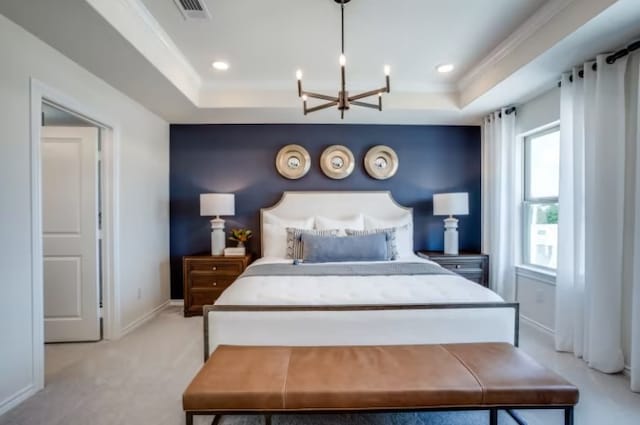 bedroom featuring light colored carpet, a tray ceiling, and an inviting chandelier