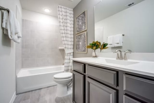 full bathroom featuring toilet, shower / bath combo with shower curtain, and vanity