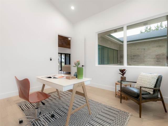 office area featuring light hardwood / wood-style floors and high vaulted ceiling