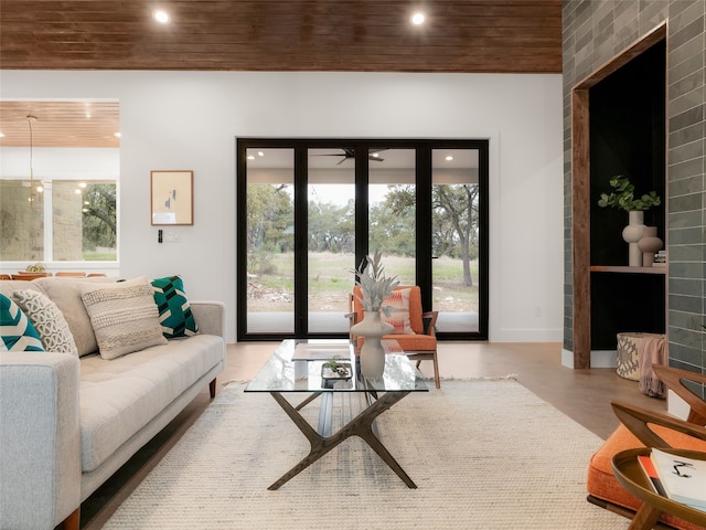 living room with a tiled fireplace and wood ceiling