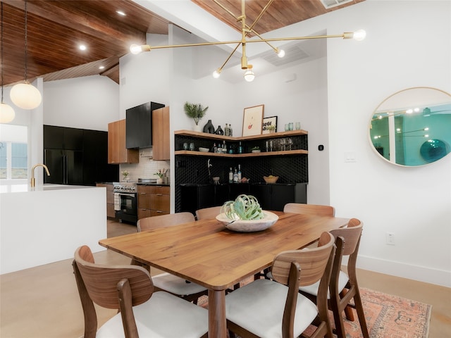 dining area featuring a towering ceiling, beamed ceiling, a chandelier, and wood ceiling