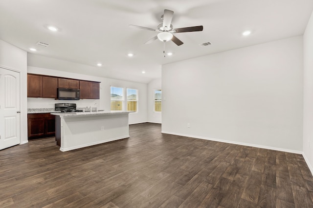 kitchen with sink, ceiling fan, an island with sink, range, and dark wood-type flooring