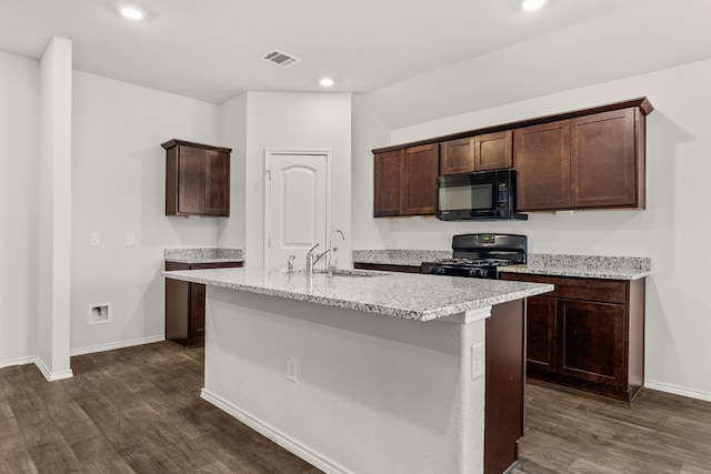 kitchen featuring dark wood-type flooring, sink, black appliances, a kitchen island with sink, and dark brown cabinetry