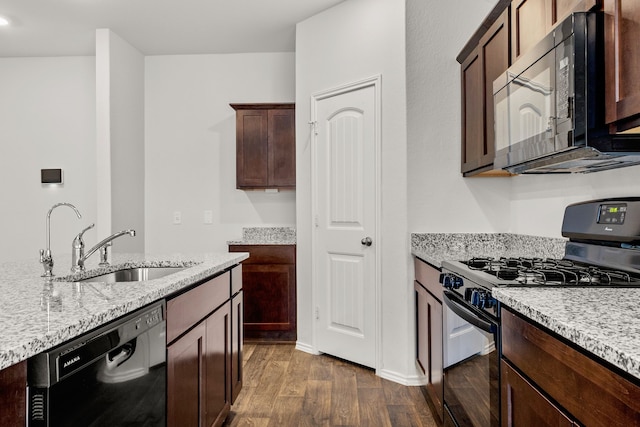 kitchen with light stone counters, dark hardwood / wood-style floors, black appliances, dark brown cabinets, and sink