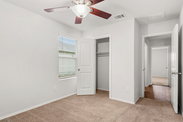 unfurnished bedroom with ceiling fan, a closet, and light carpet