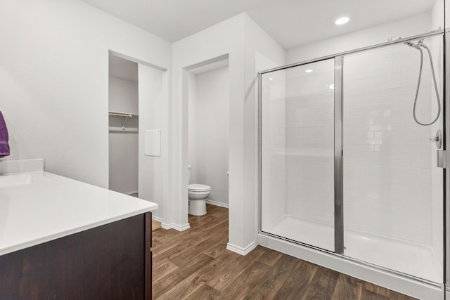 228 Rough Hollow Cv, San Marcos, TX 78666 - bathroom featuring a stall shower, wood finished floors, vanity, a walk in closet, and recessed lighting
