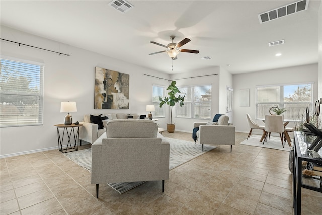 living room with ceiling fan, plenty of natural light, and light tile patterned flooring