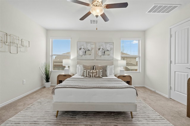 carpeted bedroom with ceiling fan and multiple windows