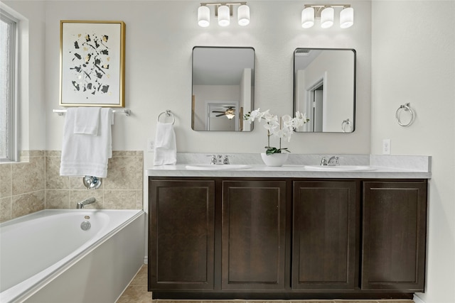 bathroom with ceiling fan, tile patterned floors, a washtub, and vanity