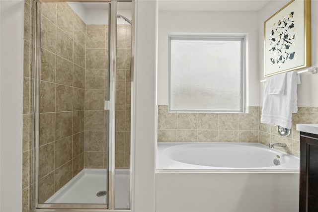 bathroom with vanity and shower with separate bathtub