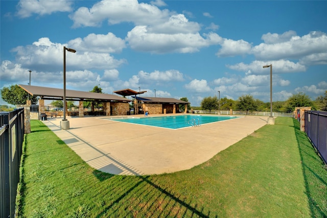 view of pool with a lawn and a patio area