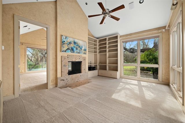 unfurnished living room with high vaulted ceiling, light carpet, and ceiling fan