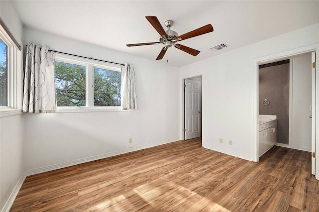 unfurnished bedroom featuring ceiling fan, hardwood / wood-style floors, and connected bathroom