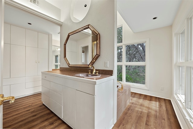 bathroom featuring vanity, hardwood / wood-style floors, and a bathtub