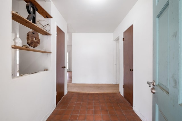 hall with dark tile patterned floors