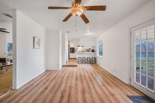 unfurnished living room with ceiling fan and light hardwood / wood-style flooring