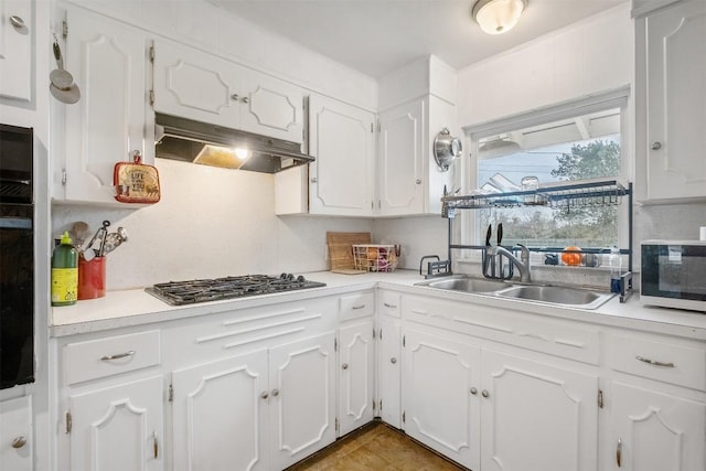 504 Marburger St, Smithville, TX 78957 - kitchen with under cabinet range hood, gas cooktop, and white cabinetry