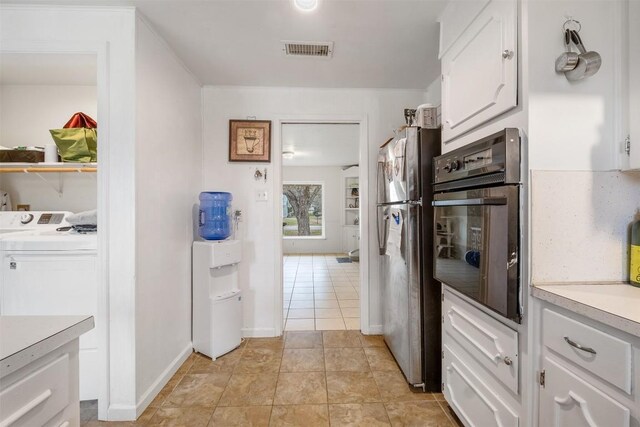 504 Marburger St, Smithville, TX 78957 - kitchen with oven, white cabinets, freestanding refrigerator, light countertops, and washer / clothes dryer