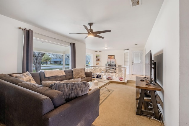 carpeted living room with ceiling fan