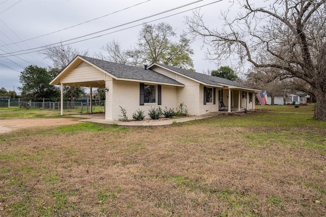 view of side of property with a carport and a lawn