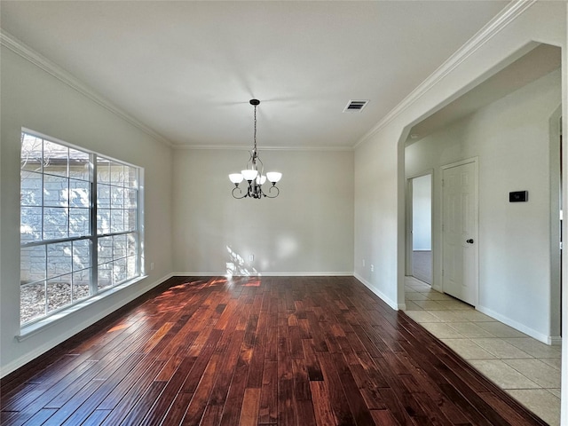 unfurnished dining area with a chandelier, light wood-type flooring, and crown molding