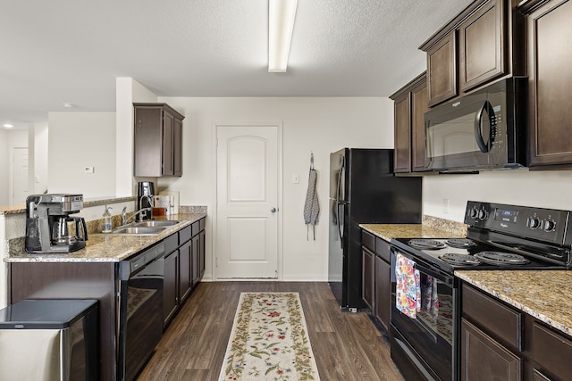 kitchen featuring light stone counters, dark hardwood / wood-style floors, sink, and black appliances