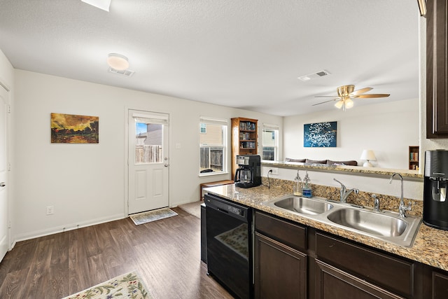 kitchen featuring dishwasher, sink, dark wood-type flooring, light stone countertops, and dark brown cabinets