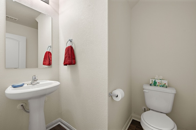 bathroom with wood-type flooring and toilet