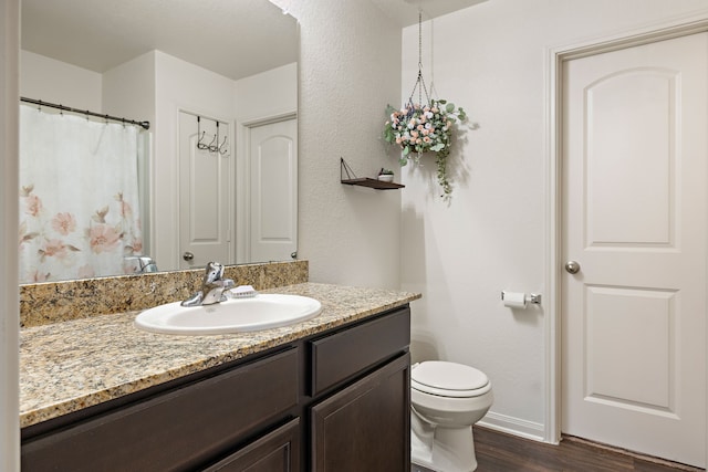 bathroom with vanity, toilet, and wood-type flooring