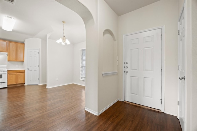 foyer with a notable chandelier and dark hardwood / wood-style floors