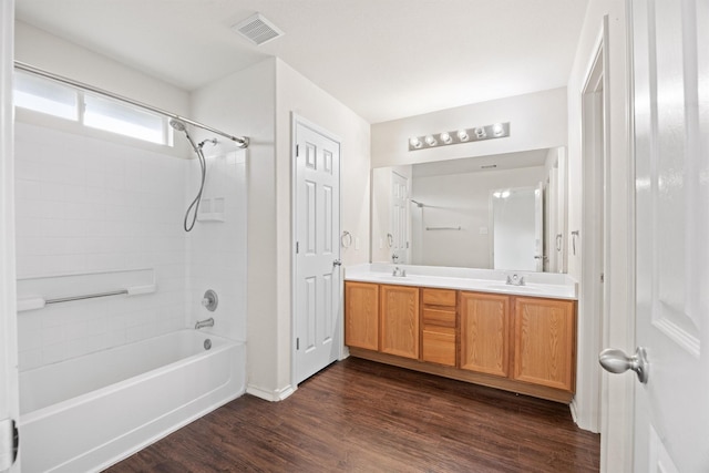 bathroom with hardwood / wood-style flooring, shower / tub combination, and vanity