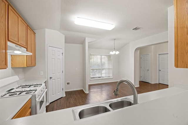 kitchen featuring dark wood-type flooring, hanging light fixtures, an inviting chandelier, white range with gas stovetop, and sink