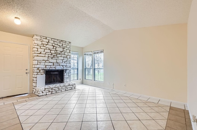 unfurnished living room featuring a textured ceiling, a stone fireplace, vaulted ceiling, and light tile patterned floors