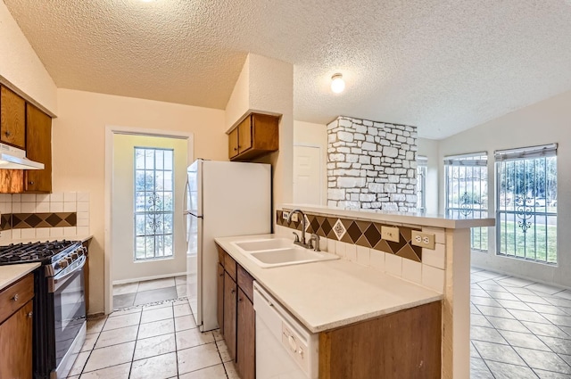 kitchen featuring white appliances, light tile patterned floors, decorative backsplash, plenty of natural light, and sink