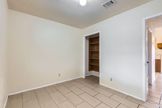 spare room with a textured ceiling